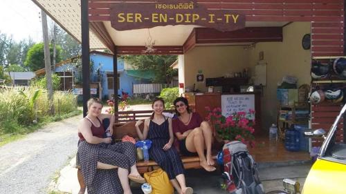 three women sitting on a bench in front of a shop at SER-EN-DIP-I-TY - SHA Extra Plus in Ko Lanta