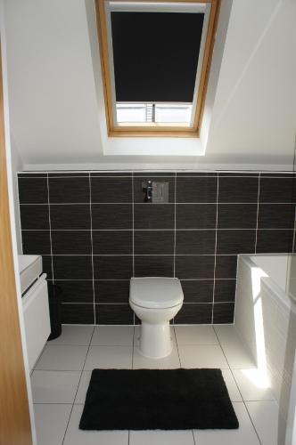 a small bathroom with a toilet and a window at No 7 Woods View in Bournemouth