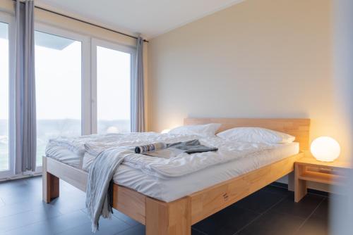 a bed in a room with a large window at Haus Calmsailing in Börgerende-Rethwisch