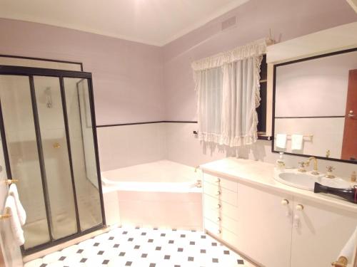 y baño con ducha, lavabo y bañera. en Ideal Business and Family accommodation, en Dandenong