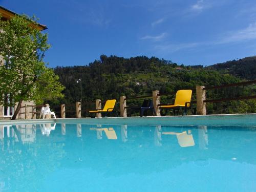a group of yellow chairs sitting next to a swimming pool at Quinta Casal De Vila Pouca in Cinfães
