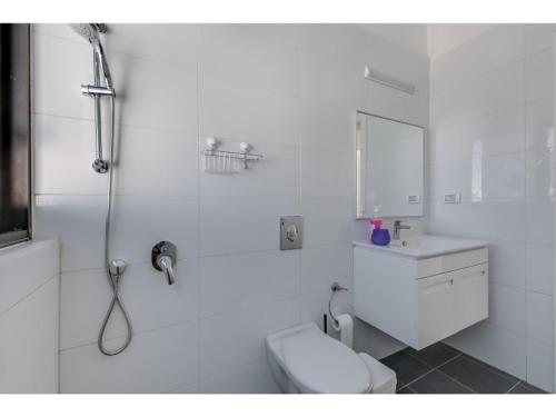 Un baño blanco con ducha y WC. en Luxury 2Bedroom brand new apt Carlton Hotel, en Tel Aviv