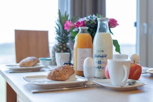 a table with plates of food and bottles of juice at Haus Calmsailing in Börgerende-Rethwisch