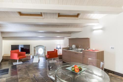a kitchen with red chairs and a glass table at Scicli Albergo Diffuso in Scicli