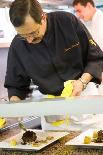 a man standing in a kitchen preparing food at L'Esplanade in Domme