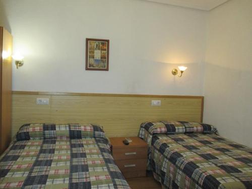 a hotel room with two beds and a picture on the wall at Pensión Martín in Jaén