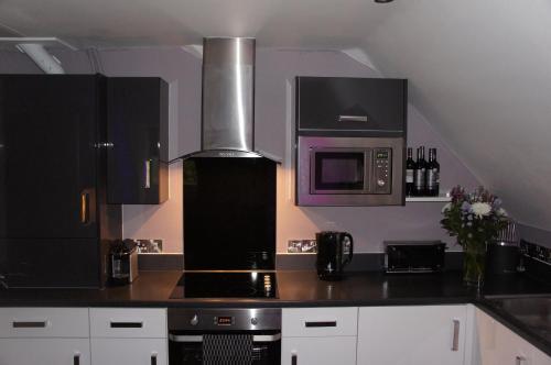 a kitchen with a stove and a microwave at No 7 Woods View in Bournemouth
