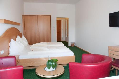 a hotel room with a bed and red chairs at Frauentalerhof in Frauental an der Lassnitz 