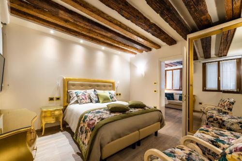 a bedroom with a bed and a chair and a mirror at Nike Appartamenti in Venice