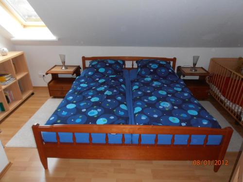 Schlafzimmer mit einem Bett mit blauer Decke in der Unterkunft FeWo Pülsen in KÃ¶hn