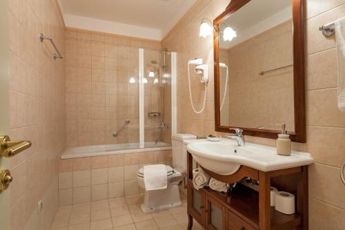 a bathroom with a sink and a toilet and a mirror at Seafront Serenity Villa Mir Vami - Your Family Oasis by the Shore in Sumartin