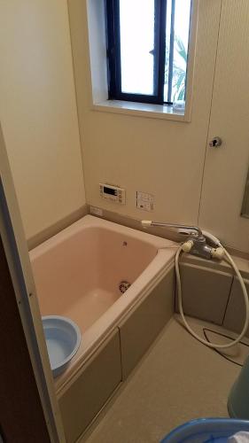 a bath tub in a room with a window at 四万川 in Yaochō