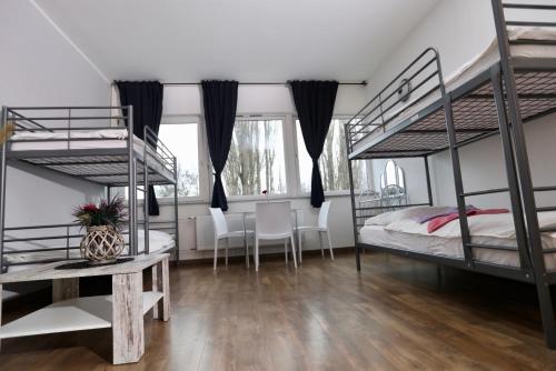 a bedroom with bunk beds and a table and chairs at Elsässer Hostel in Hamburg