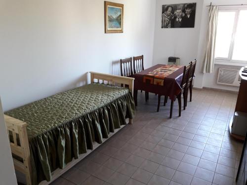 1 dormitorio con mesa, cama, mesa y sillas en Departamento Avda Belgrano Sur 367 con Cochera Privada en Santa Rosa