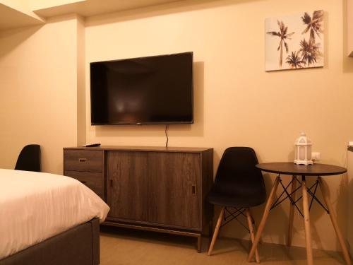 Schlafzimmer mit einem TV, einem Bett und einem Tisch in der Unterkunft Centrio Tower Beside Ayala Studio Unit -24 in Cagayan de Oro