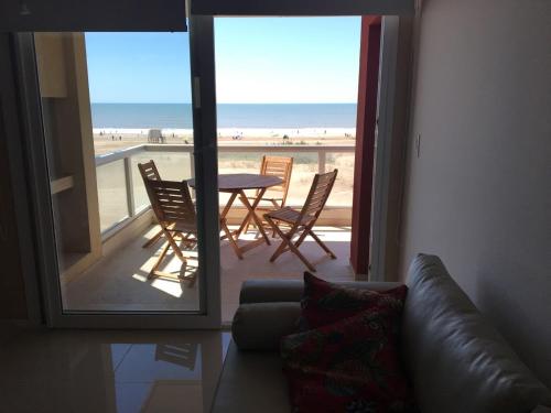 a living room with a couch and a view of the beach at Mirasoles 20 in Las Gaviotas