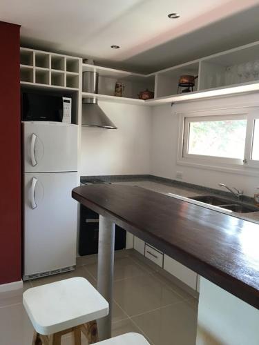 a kitchen with a white refrigerator and a table at Mirasoles 20 in Las Gaviotas