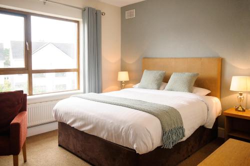 a bedroom with a large bed and a window at Clifden Coach House in Clifden