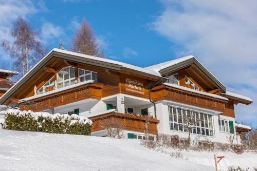 una casa en la cima de una ladera cubierta de nieve en Gästehaus Büchele, en Hirschegg