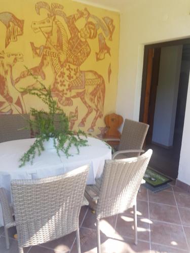 a table and chairs with a painting on the wall at Vila Krpan Kranjska Gora in Gozd Martuljek