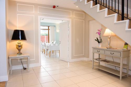 a hallway with a staircase and a table with a lamp at Clifden Coach House in Clifden
