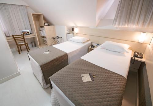 TeutôniaにあるBaviera Park Hotelのベッド2台と机があるホテルの部屋