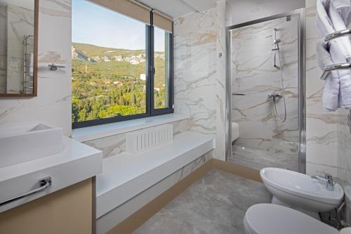 baño con aseo y ventana en Foros Health Resort, en Foros