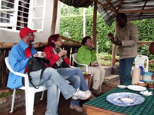 a group of people sitting in chairs under an umbrella at Machame Nkweshoo Cultural Tourism in Machame