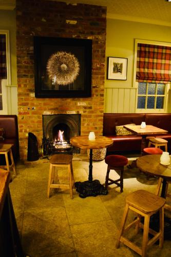 a room with a fireplace and tables and a fire place at The Devonport in Darlington