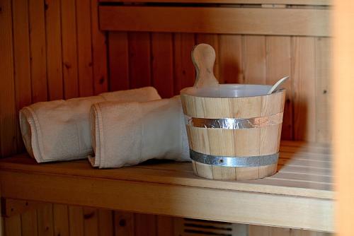 a wooden bucket on a shelf with a wooden spoon at Camping Cadí Vacances & Spa in Gósol