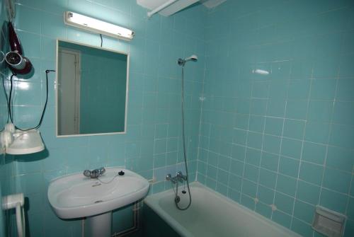 サロウにあるZeus Tauroの青いタイル張りのバスルーム(シンク、バスタブ付)