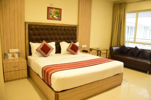 a bedroom with a large bed and a couch at Rama Trident, Katra in Katra