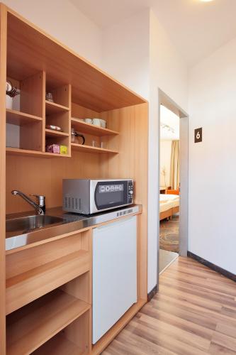 エッセンにあるPetul Apart Hotel Residenzのシンクと電子レンジ付きのキッチン
