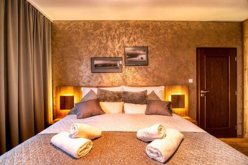 a bedroom with a large bed with two towels on it at Apartman Lio - free garage parking in Tatranská Lomnica