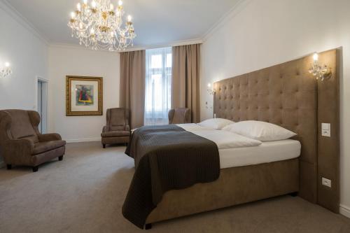 a bedroom with a large bed and a chandelier at Apartmány Arte in Brno