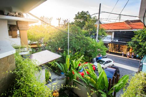 a view of a street from a balcony with plants at Kuta Suci Guesthouse in Kuta