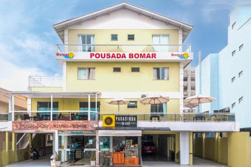 un bâtiment jaune avec un panneau indiquant pusska bonnard dans l'établissement Pousada Bomar Bombinhas, à Bombinhas