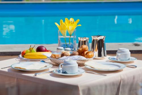 a table with plates of food and fruit on it at Hotel Delfino Lugano in Lugano