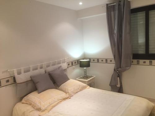 une chambre avec un lit avec une lampe et une fenêtre dans l'établissement T2 Mandelieu, vue exceptionnelle, à Mandelieu-la-Napoule