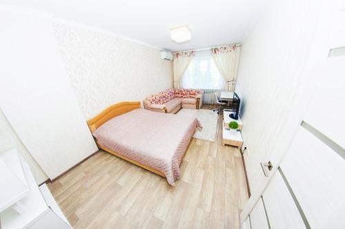 um pequeno quarto com uma cama e uma secretária em ATLANT Apartments 99 em Voronezh
