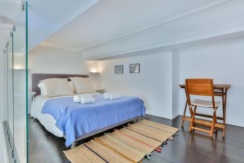 Schlafzimmer mit einem Bett mit einem Stuhl und einem Schreibtisch in der Unterkunft Maison Bianchi - Duplex old town in Nizza