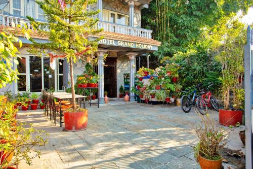 sklep ogrodowy ze stołami, krzesłami i roślinami w obiekcie Hotel Grand Holiday w mieście Pokhara