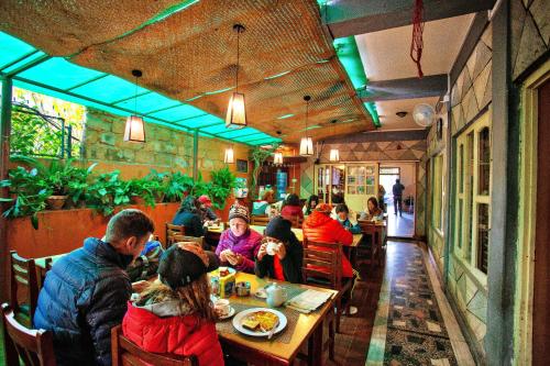un grupo de personas sentadas en una mesa en un restaurante en Hotel Grand Holiday en Pokhara
