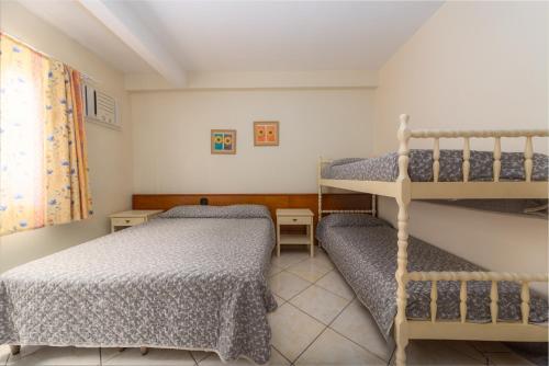 a bedroom with two bunk beds and a window at Residencial Kelly Cristina in Bombinhas