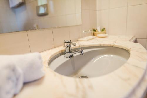 a bathroom with a sink and a mirror at Hotel Restaurant Kirchsteiger in Vollan