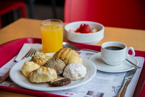 a tray with a plate of pastries and a cup of coffee at Hotel Moov Curitiba in Curitiba