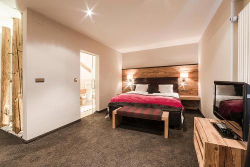a hotel room with a bed and a television at Hotel Restaurant Kirchsteiger in Vollan