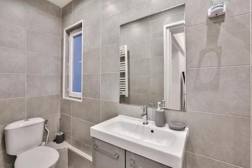 une salle de bain avec un lavabo, des toilettes et un miroir dans l'établissement 34 - Urban Luxury Paris Louvre, à Paris