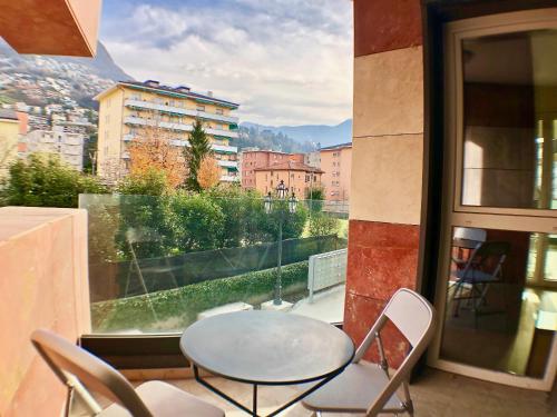 a table and chairs on a balcony with a window at Roggia Apartments by Quokka 360 - a stone's throw from Ciani Park in Lugano