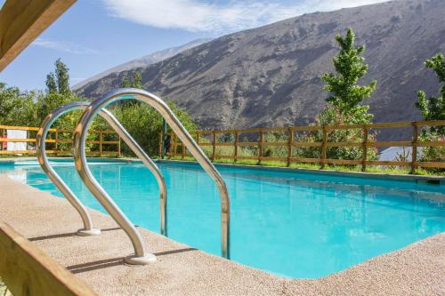 a swimming pool with a mountain in the background at Cabañas Los Sauzales in Pisco Elqui